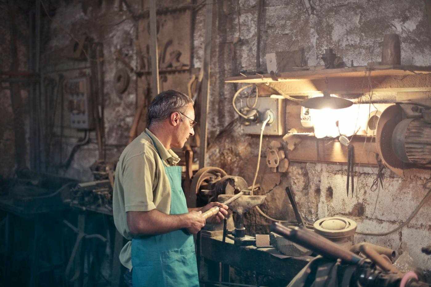 Erfahrener Handwerker an einer Maschine in seiner Werkstatt